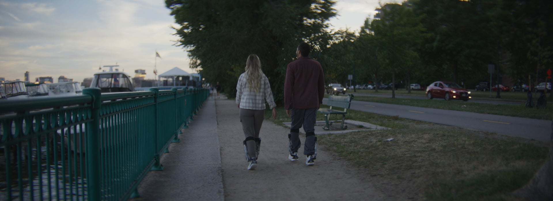 A couple walking together along a riverside promenade